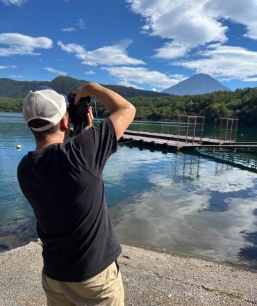 Photographer taking pictures during a Fuji Photo Tour with Mt. Fuji in the background.