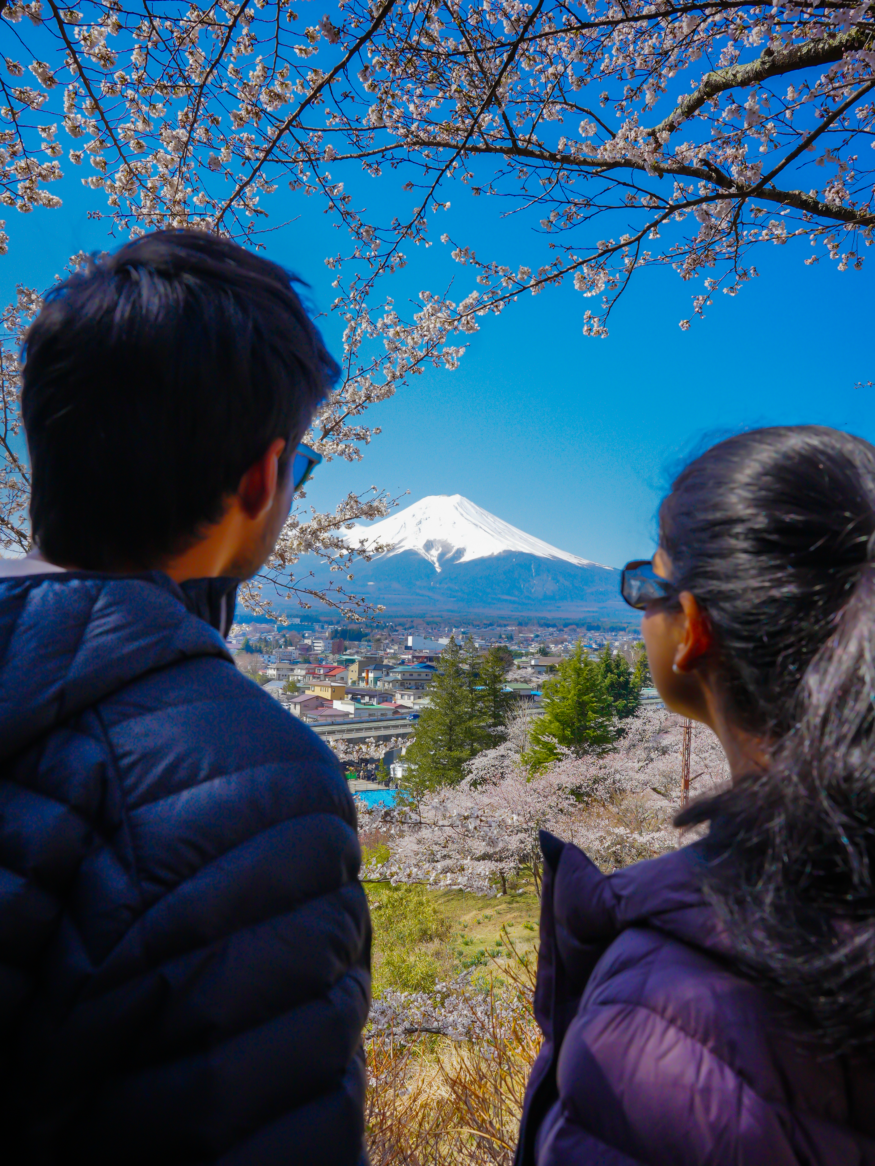 Couple standing near Chureito Pagoda with Mt. Fuji in the background, sharing a romantic travel moment.