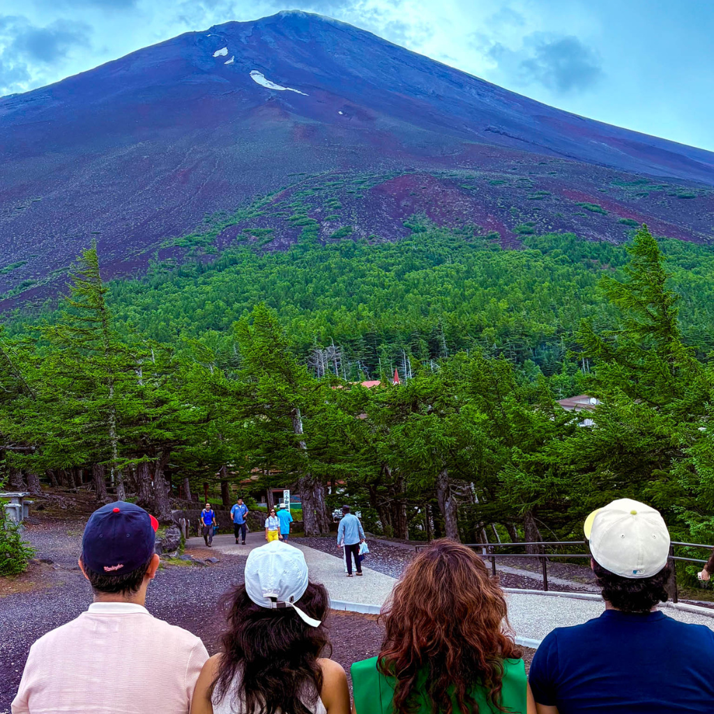 American family seen from behind at Mt. Fuji’s 5th Station, looking out over the vast slopes of the mountain.