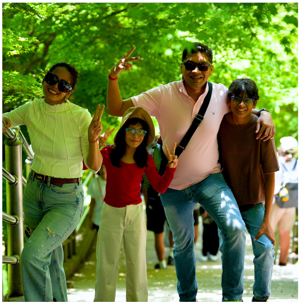 Indian family posing on the autumn-colored stairs leading to Chureito Pagoda during a Mt. Fuji photo tour.