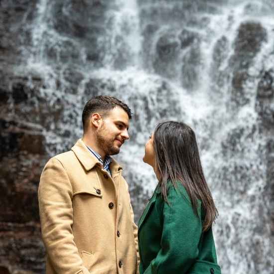Couple standing in front of Haha-no-Shirataki Waterfall near Lake Kawaguchiko, Yamanashi, Japan