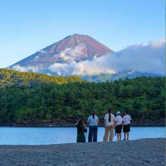 Two guests photographed at Koyodai during a private Mt. Fuji photo tour, enjoying the warm light and panoramic scenery at sunset.