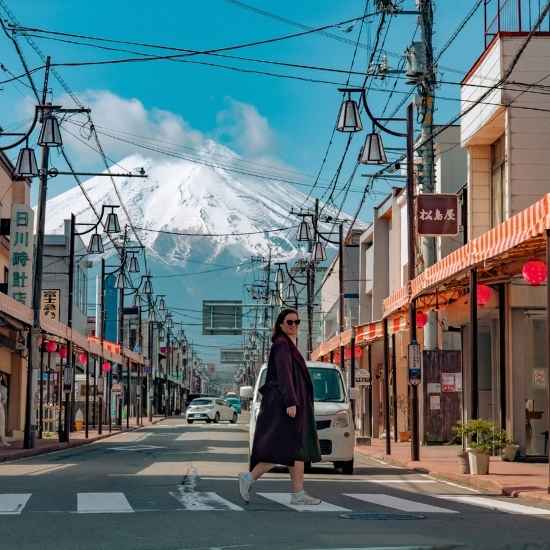Traveler crossing Honcho Street with Mt. Fuji in the background in Fujiyoshida, Yamanashi, Japan