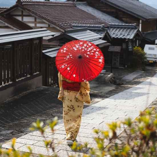 Guest wearing a kimono and carrying a red Japanese umbrella