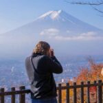 American photo tour guest taking a picture of Mt. Fuji and autumn leaves