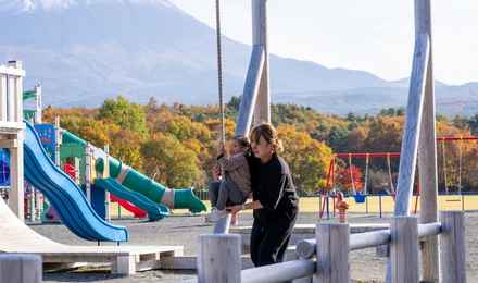 Children playing on the grass field with Mt. Fuji at Narusawa Ikiiki Square